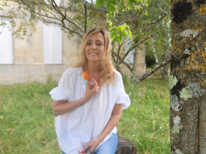 Anne Misson souriante, tenant son collier