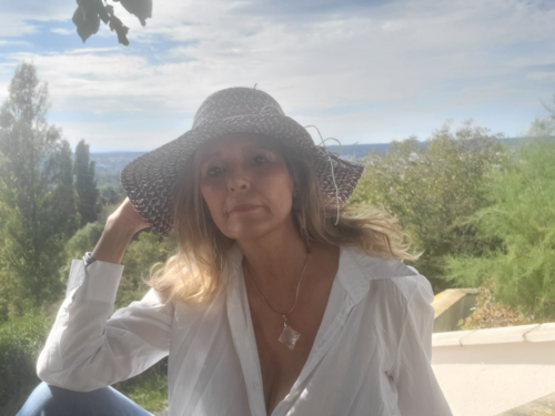 Anne Misson portant un chapeau devant un paysage verdoyant