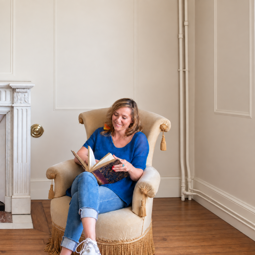 Anne Misson assise avec un livre, au fil de ses apprentissages